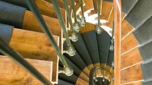 A spiral staircase with wooden steps and metal railings.