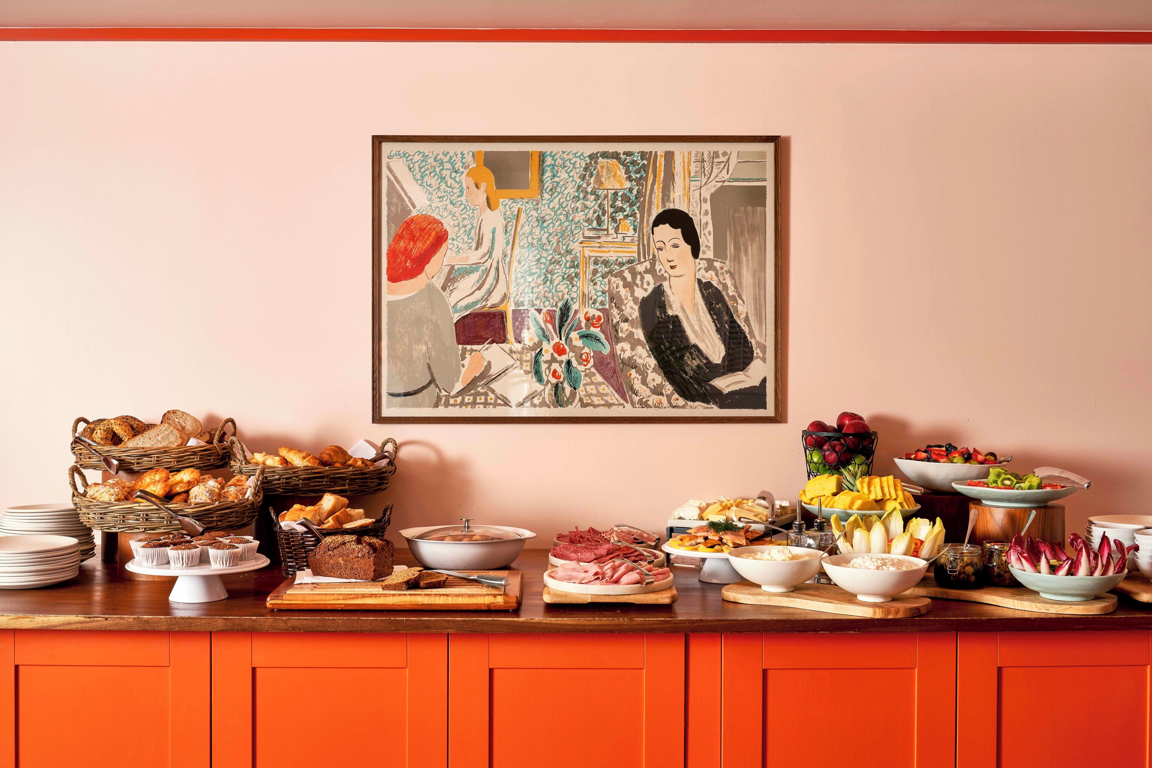 Une table de buffet garnie de différents plats et un tableau accroché au mur.