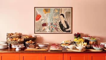 Une table de buffet garnie de différents plats et un tableau accroché au mur.