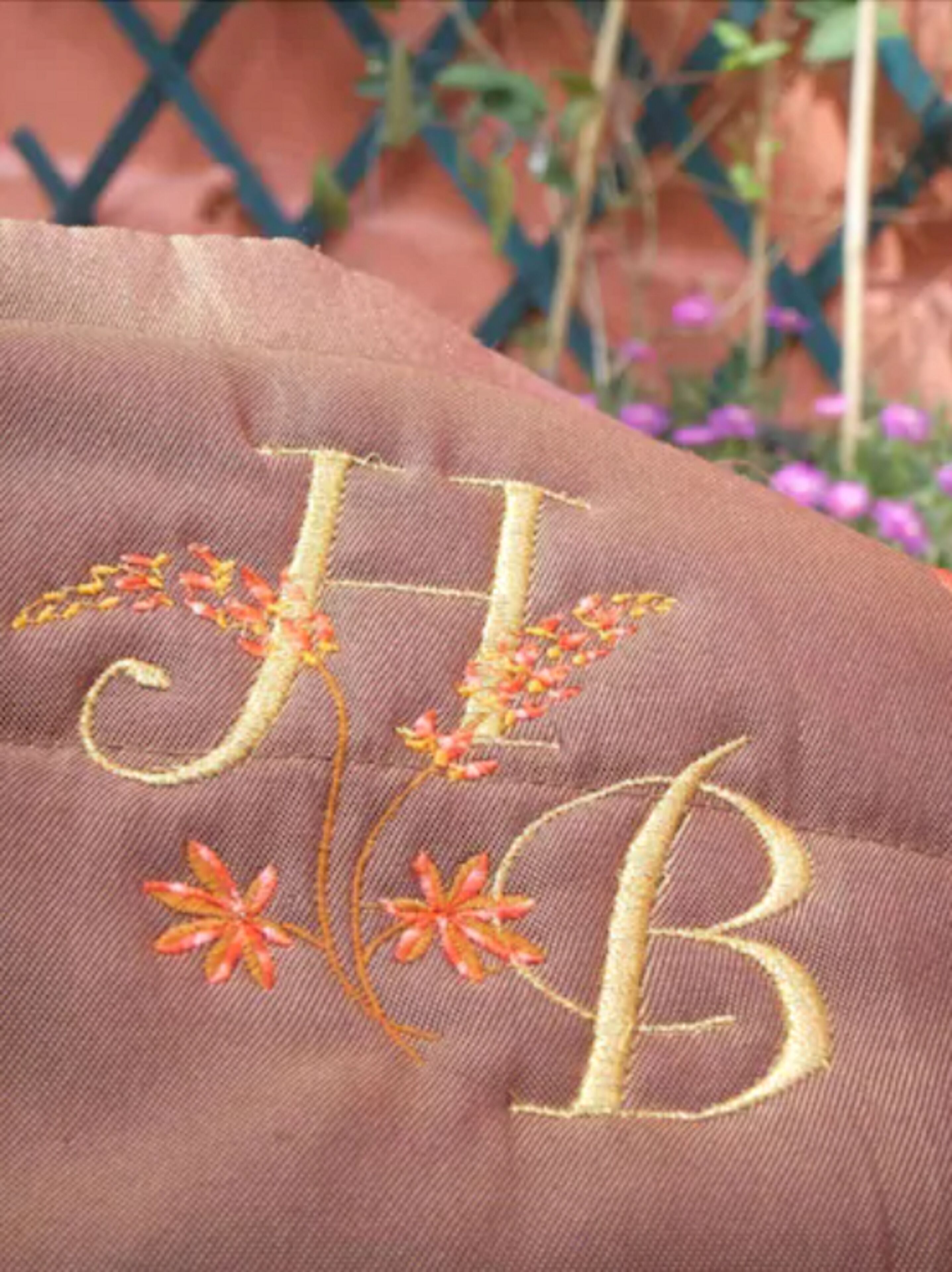 A close-up of a fabric with embroidered initials and floral designs.