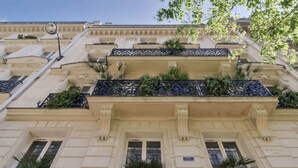 A multi-story building with balconies, a street lamp, and a sign indicating the building number 30. - Hôtel Palm - Astotel (Paris)