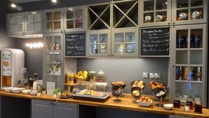 Zona de desayuno tipo buffet con diversas opciones de comida y bebidas.