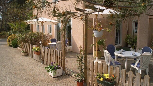 A patio with outdoor seating, a wooden fence, and potted plants. - Stars Antibes (Antibes)