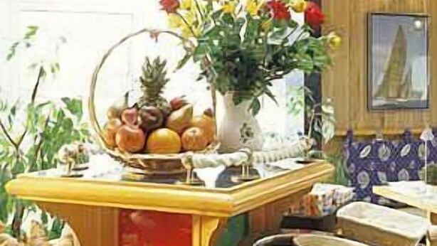 Un buffet de petit-déjeuner proposant une variété d’aliments et agrémenté d’un vase de fleurs.