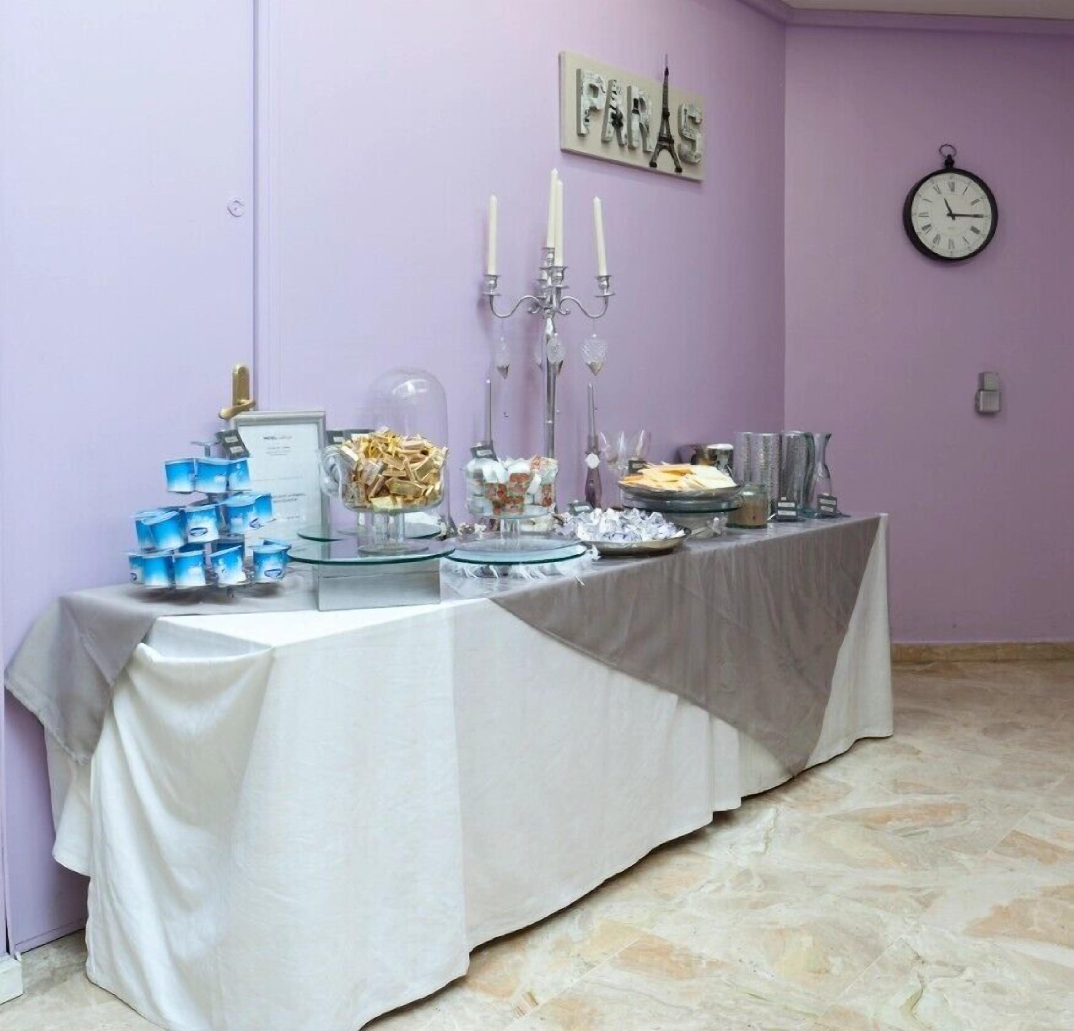 A buffet table with various food items and a clock on the wall.
