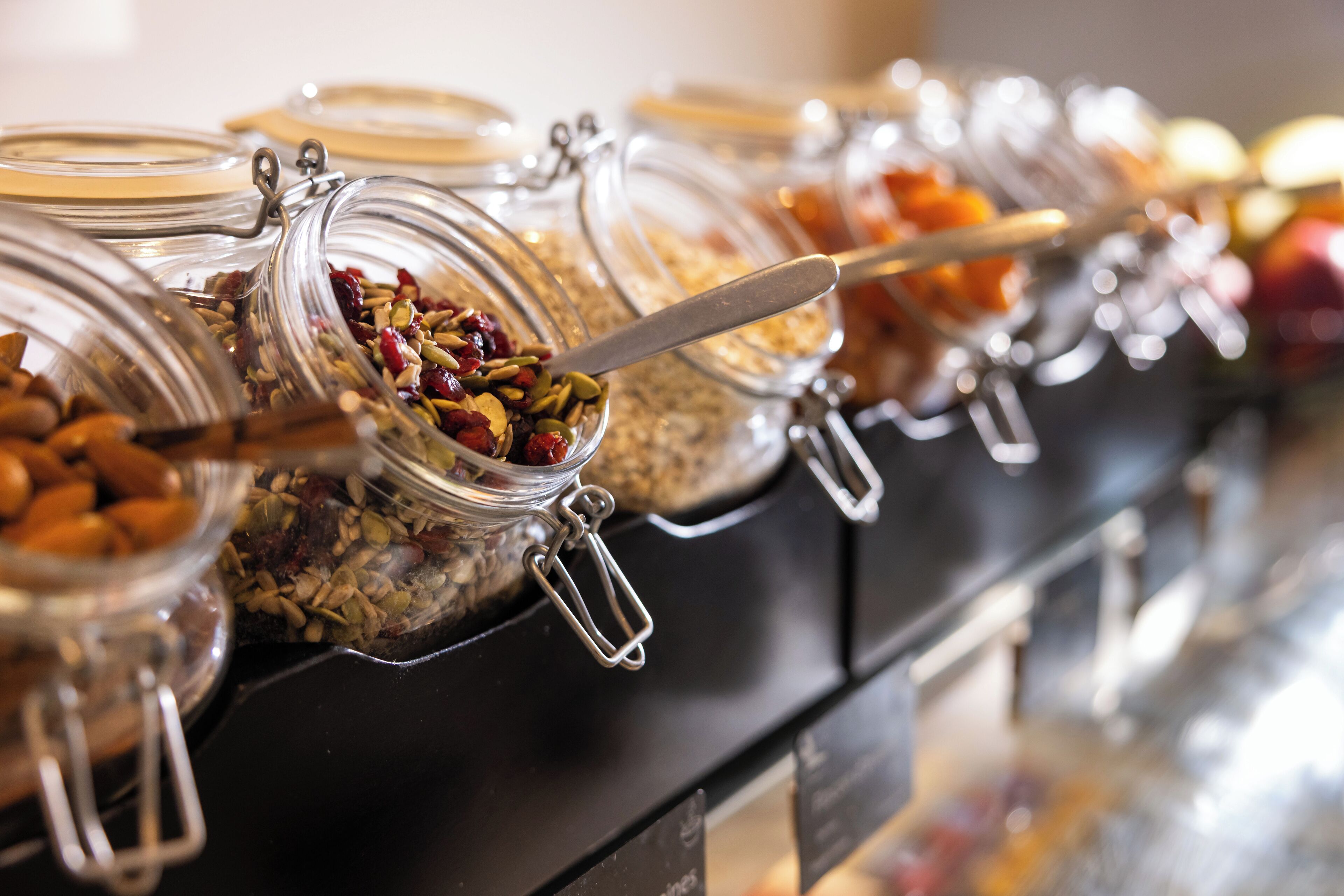 Un bufé con diferentes alimentos en recipientes de vidrio.