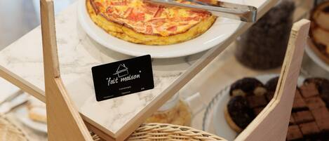 Una exhibición de productos horneados, como una quiche y pasteles, sobre una encimera de mármol.