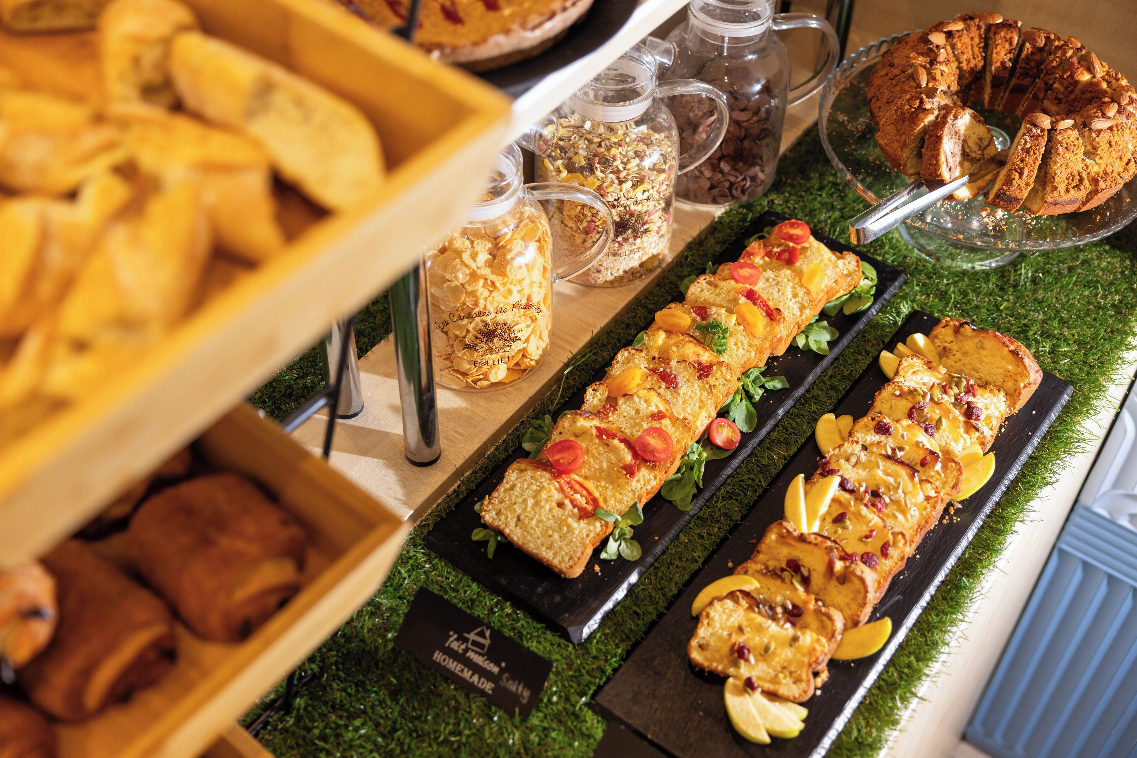 Un buffet con diversi cibi, tra cui una pagnotta, pasticcini e una torta.