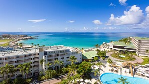 Un resort con piscina, vista a la playa y varias edificaciones.
