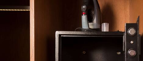 A compact microwave with a control panel and a small cup holder in a wooden cabinet.
