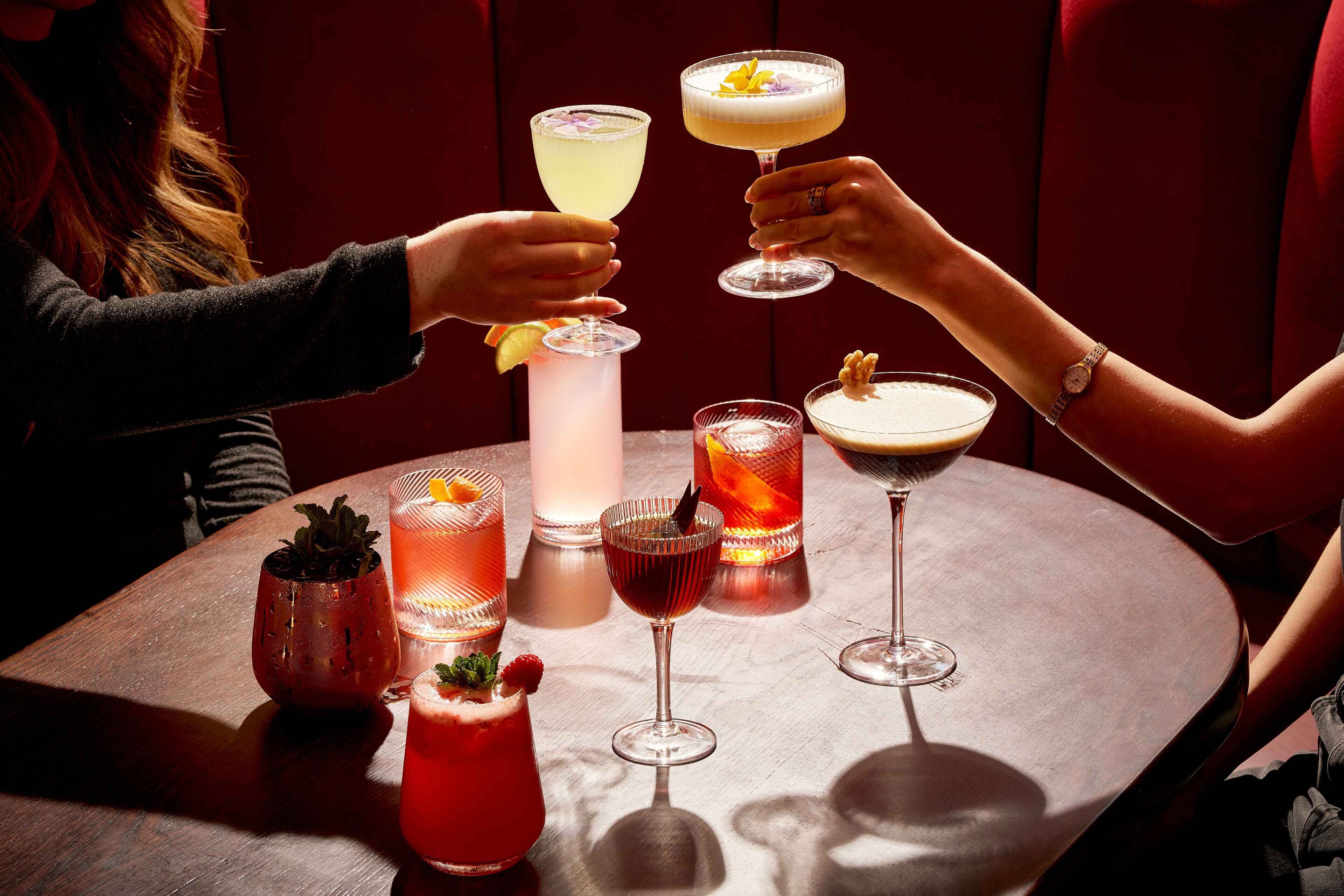 Una mesa con diversas bebidas y una copa decorativa.