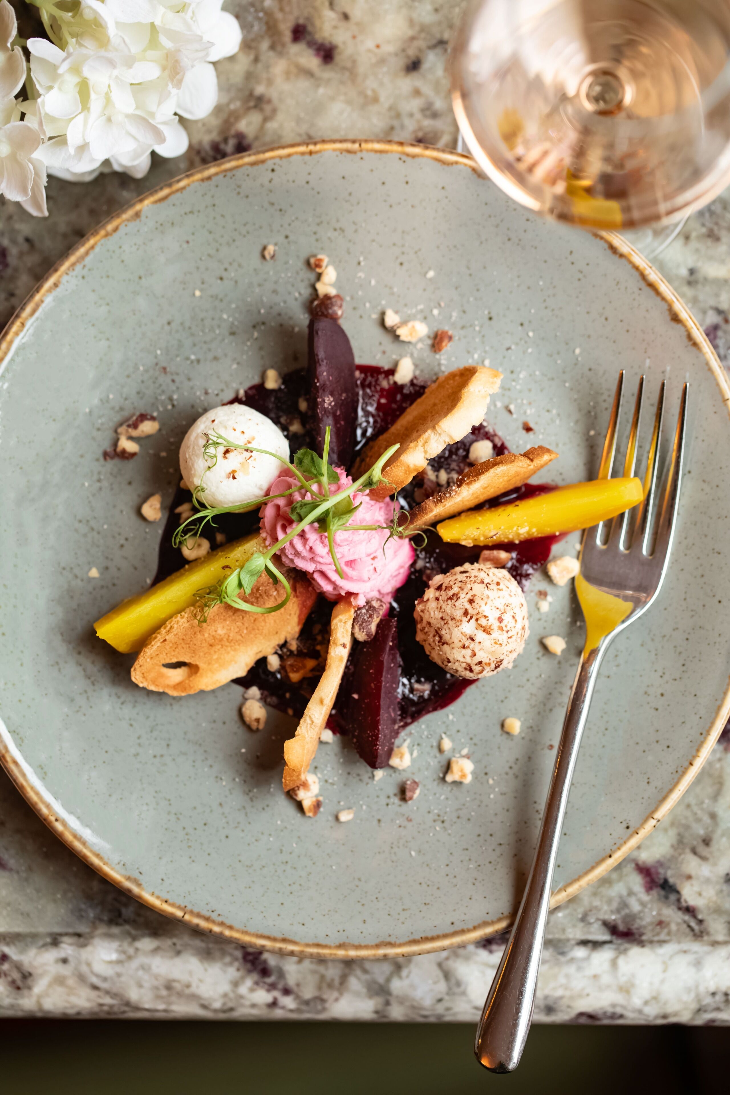 Un plato de comida con varios elementos, incluyendo una porción de helado, un trozo de pastel y fruta.