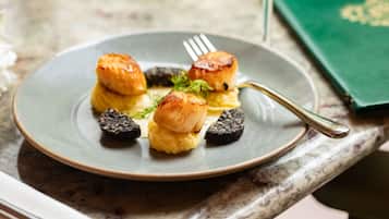 Een bord met coquilles en puree op een marmeren blad.