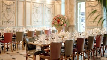 Comedor con varias mesas dispuestas para el servicio, sillas y un gran centro de flores.