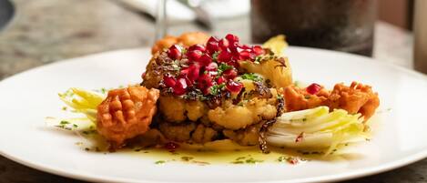 A plate of food with a glass of wine on a table.