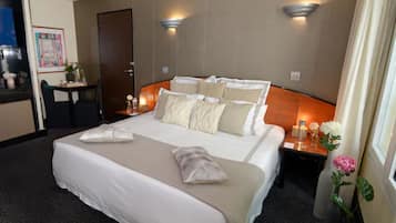 A hotel room with a large bed, two bedside tables, a desk, and a chair.