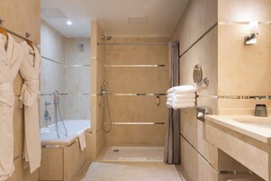 Un baño moderno con cabina de ducha, bañera y tocador con espejo.