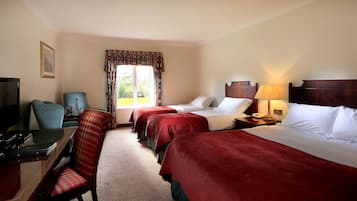A hotel room with two beds, a desk with a computer, a chair, and a television.