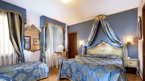 A bedroom with two beds, a mirror, a nightstand, and a chair. - San Marco Palace (Venice)