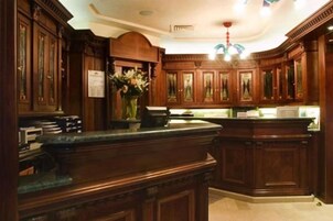 Una cucina tradizionale con mobili in legno, un piano di lavoro in marmo e un lampadario.