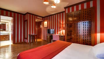 A hotel room with a bed, a television, a desk, and a wardrobe.