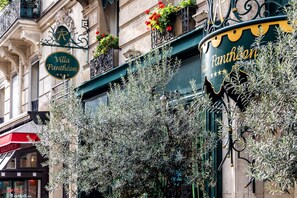Um edifício com uma placa que diz "Villa Panthéon" e um toldo verde.