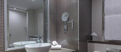 Un baño moderno con dos lavamanos, un espejo grande y un perchero para toallas.