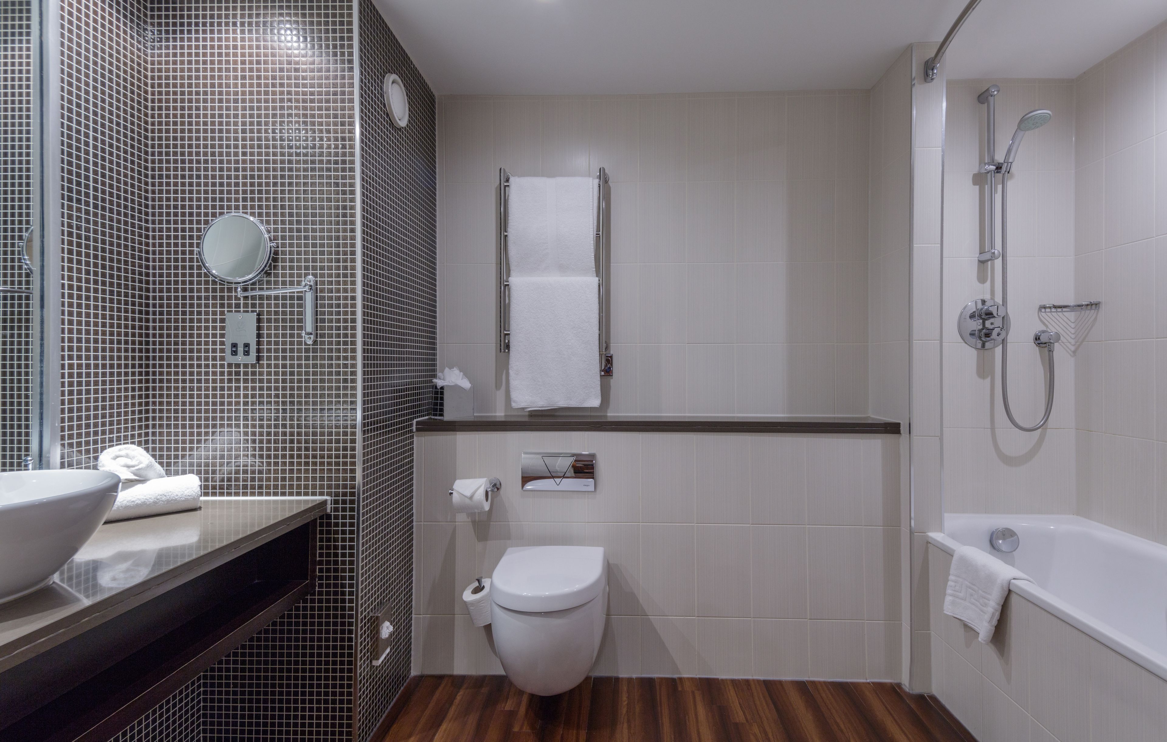 Un baño moderno con inodoro, lavamanos y ducha.