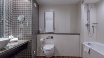 Un baño moderno con inodoro, lavamanos y ducha.