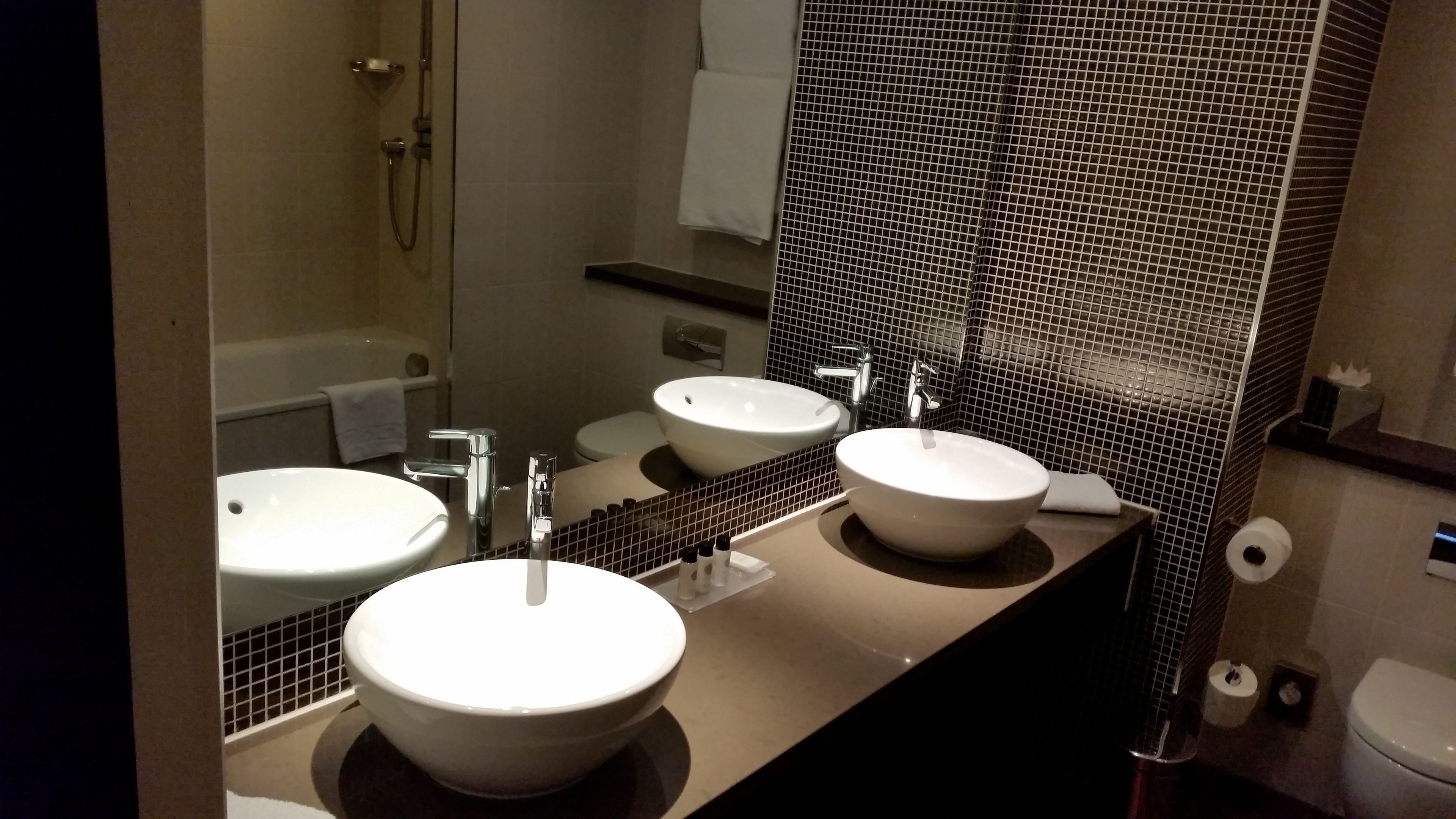 A bathroom with two sinks, a bathtub, and a toilet.