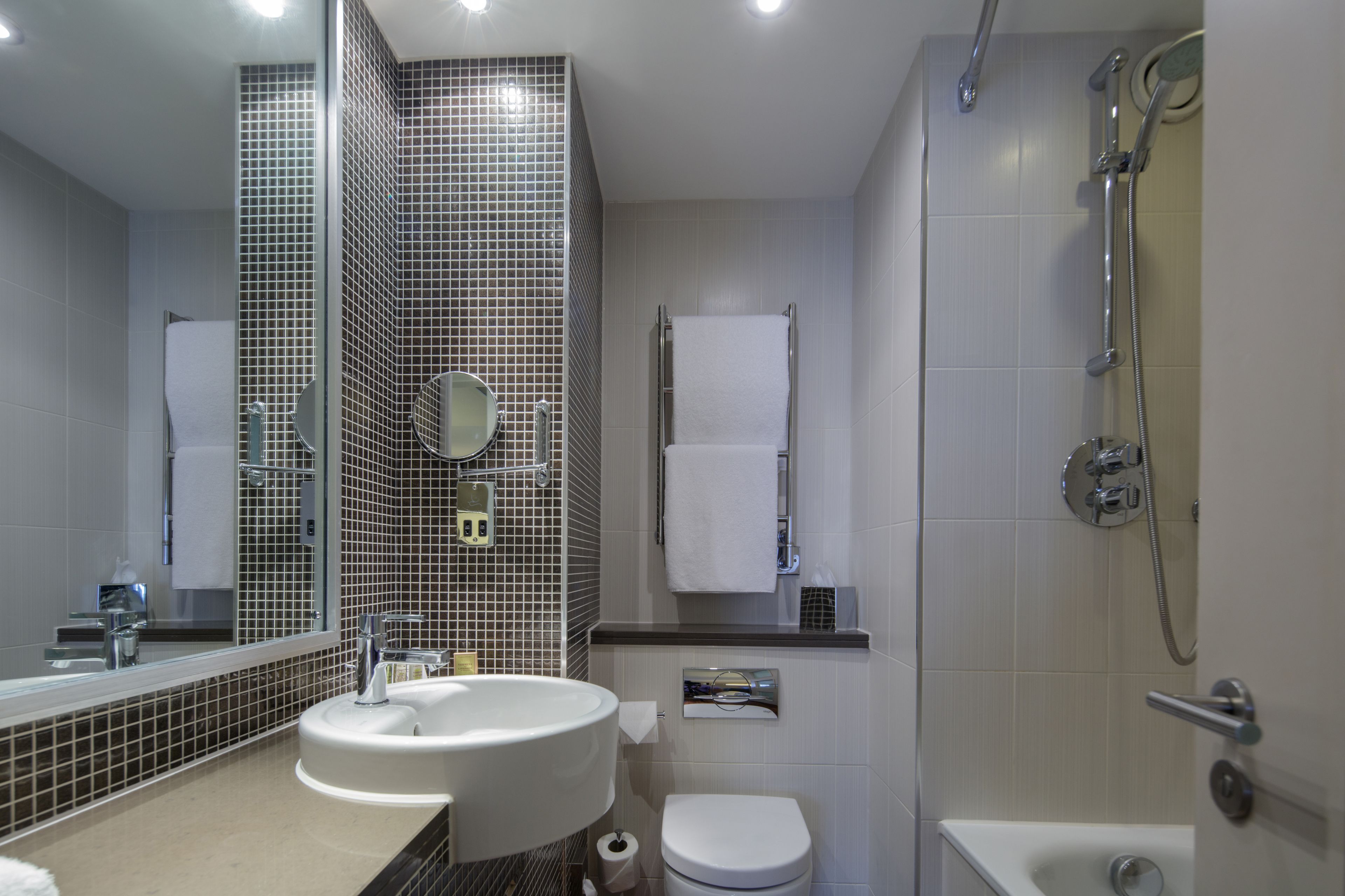 A modern bathroom with a sink, toilet, and shower.