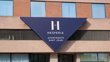 Un edificio con un cartel que indica Hesperia Apartments Sant Joan.