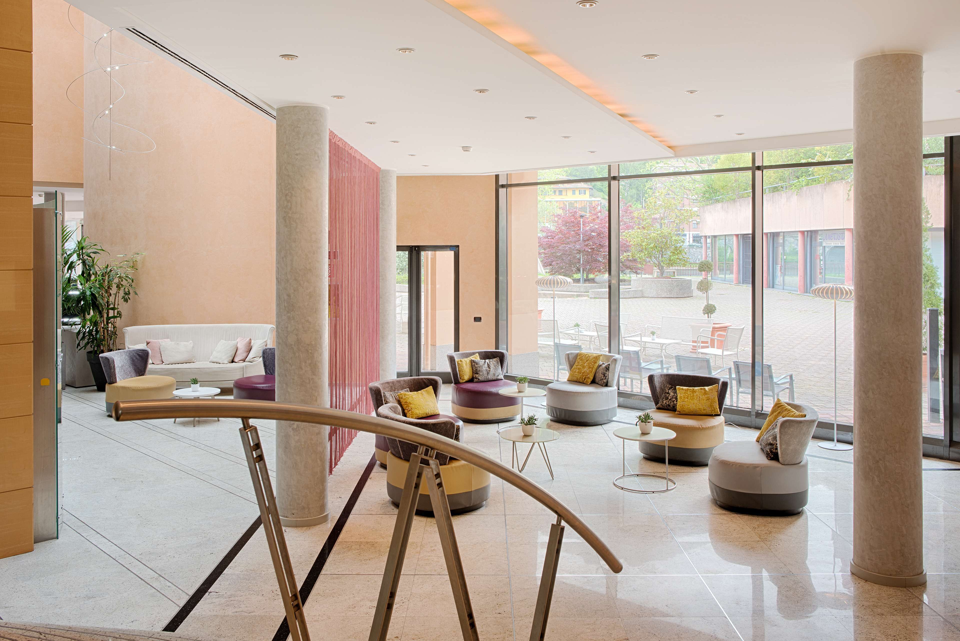 A spacious lobby with modern seating, large windows, and a view of the outside.
