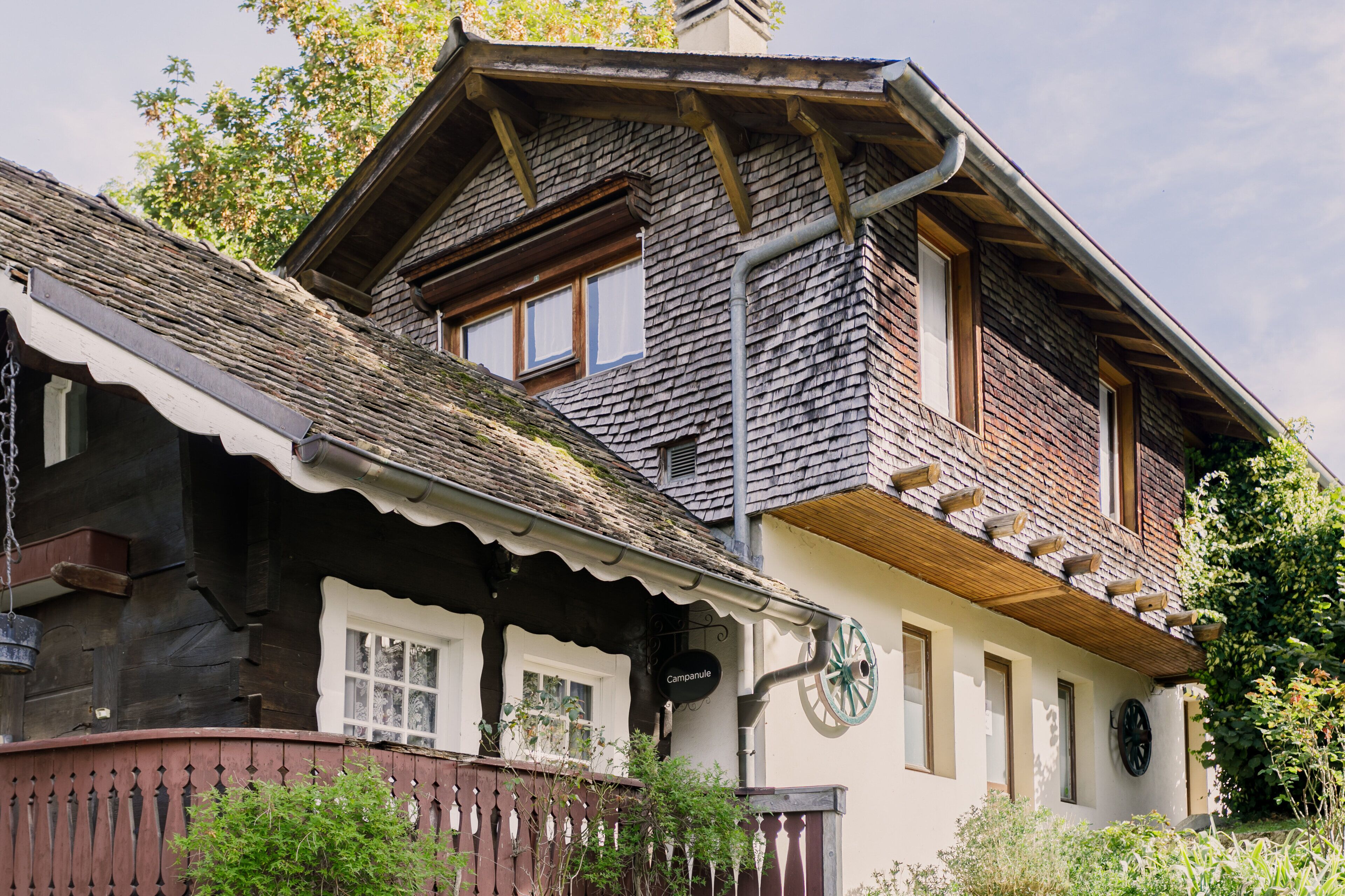 Un chalet traditionnel doté d’un toit à pente, de balcons en bois et d’une façade rustique.