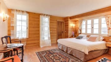 Una habitación de cabaña de madera con una cama, un escritorio con una computadora portátil y una silla.