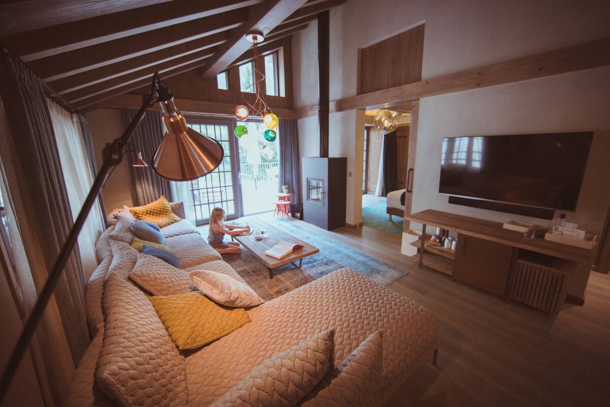 Ett rymligt vardagsrum med en stor soffa, en tv och en matplats.