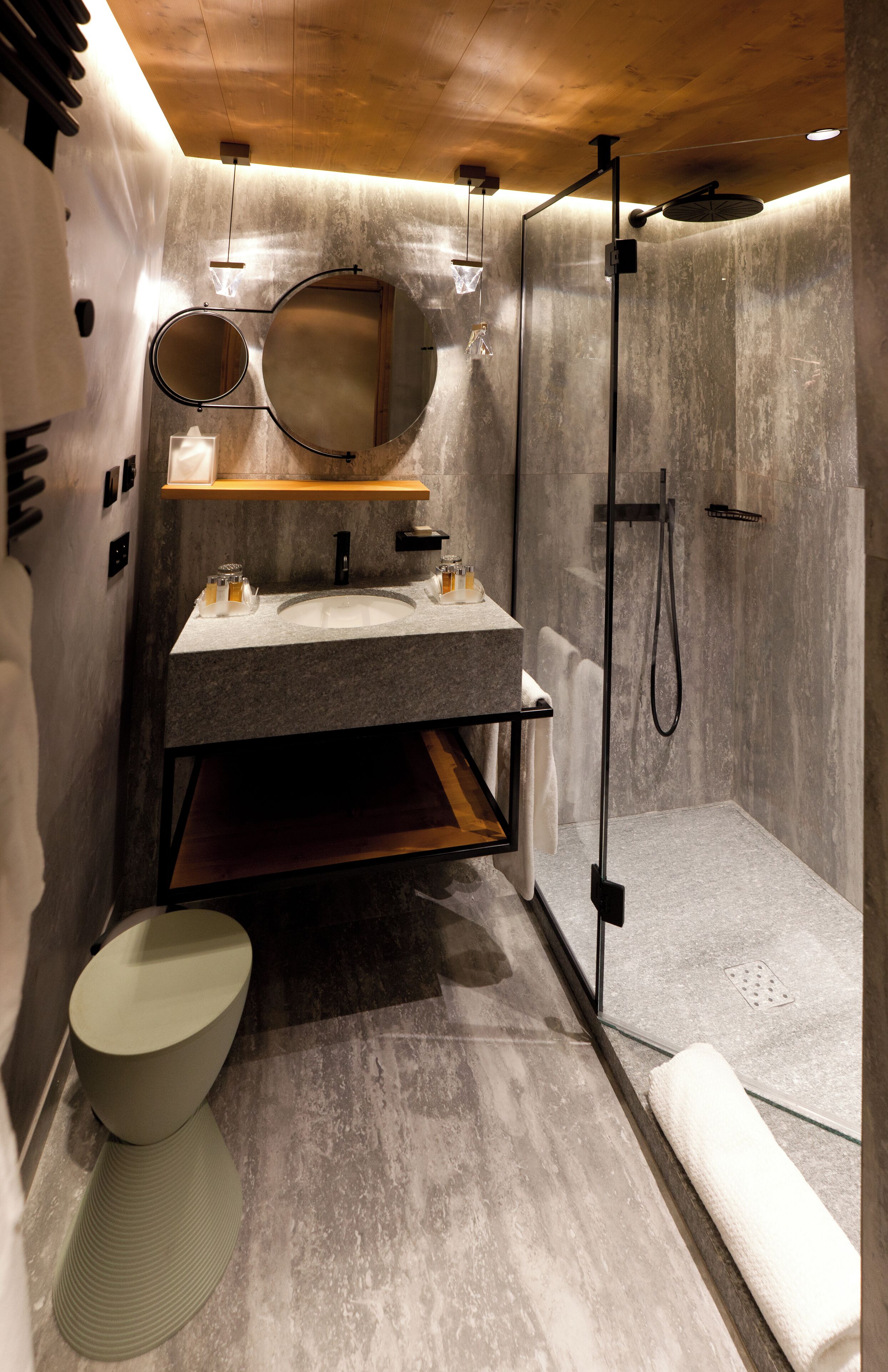 A modern bathroom with a large mirror, two sinks, a toilet, and a shower area.