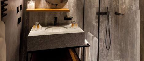 A modern bathroom with a large mirror, two sinks, a toilet, and a shower area.