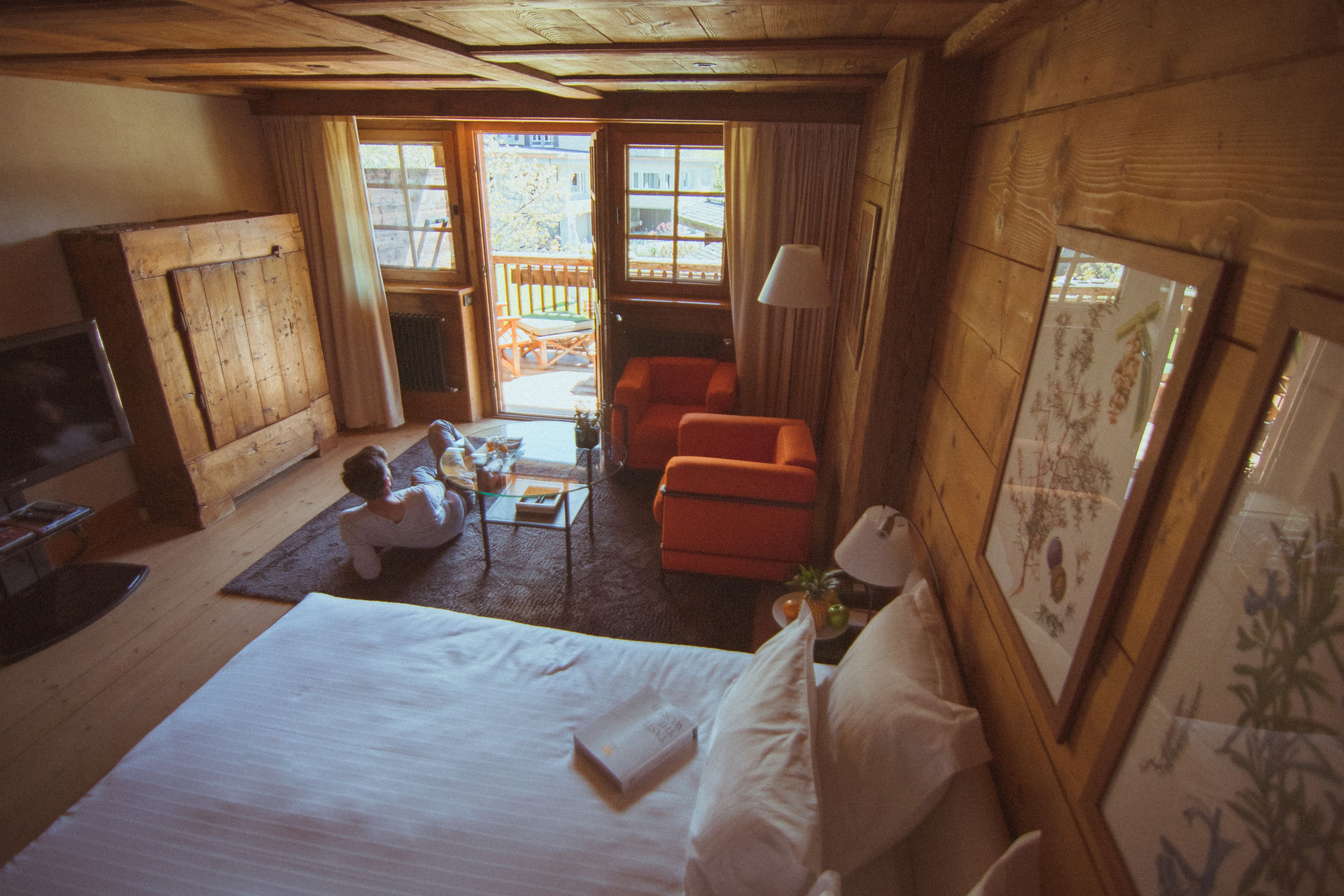 Una habitación acogedora con una cama, una mesita, una silla y un televisor.