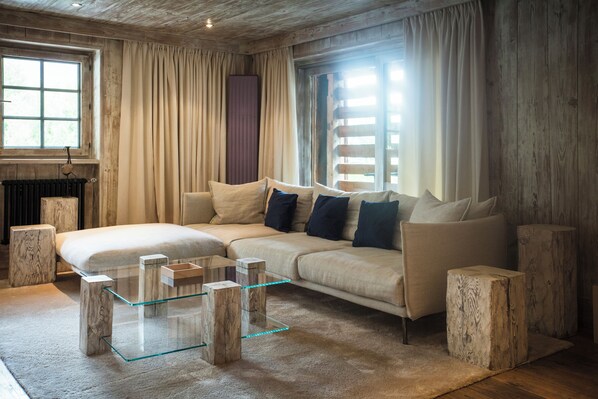A cozy living room with a sectional sofa, a glass coffee table, and wooden accents.