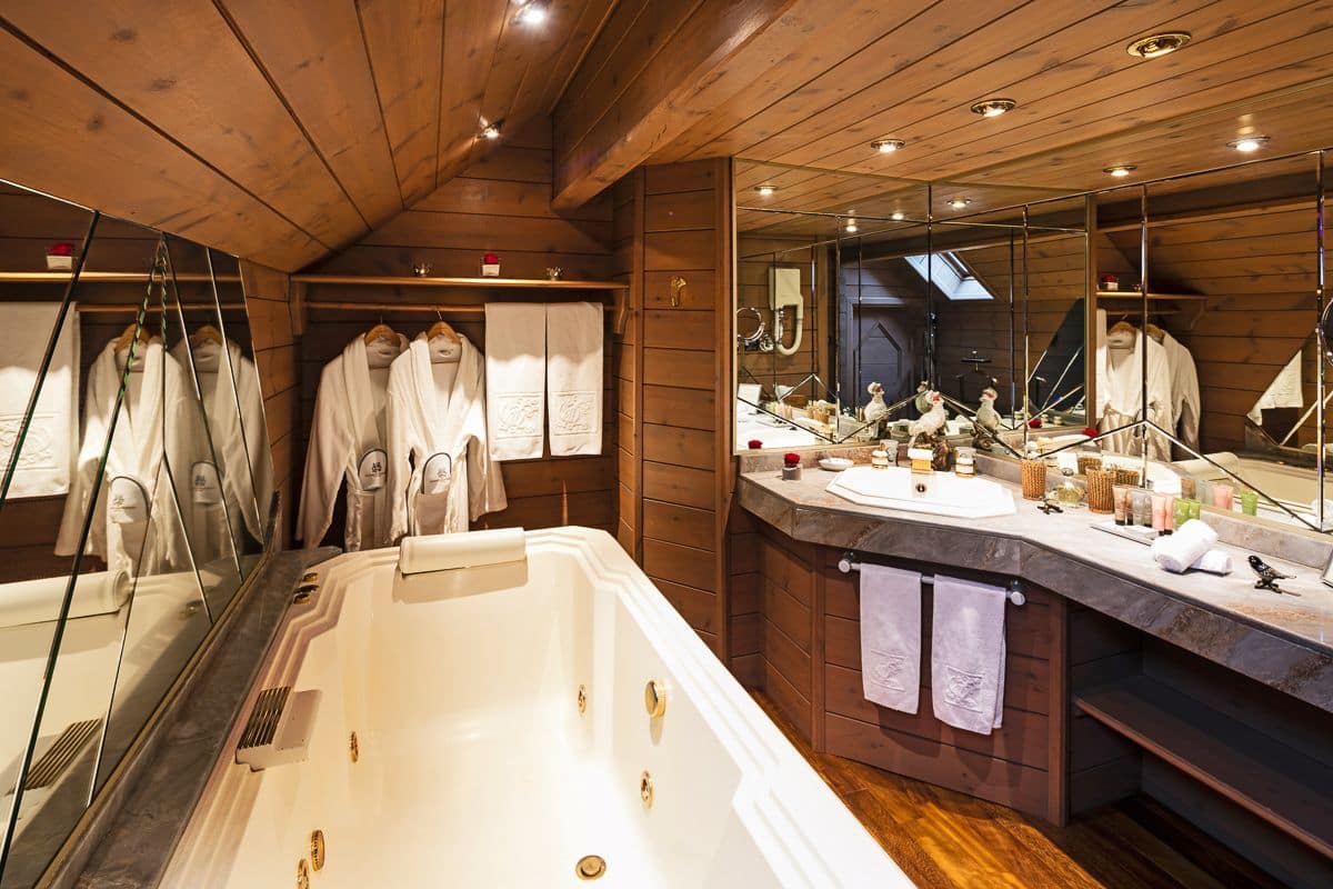 Un baño moderno con una bañera grande, techo de madera y tocador con espejo.