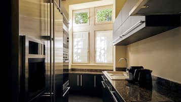 Una cucina moderna con elettrodomestici in acciaio inossidabile, un piano di lavoro in granito e una finestra che si affaccia sul verde.