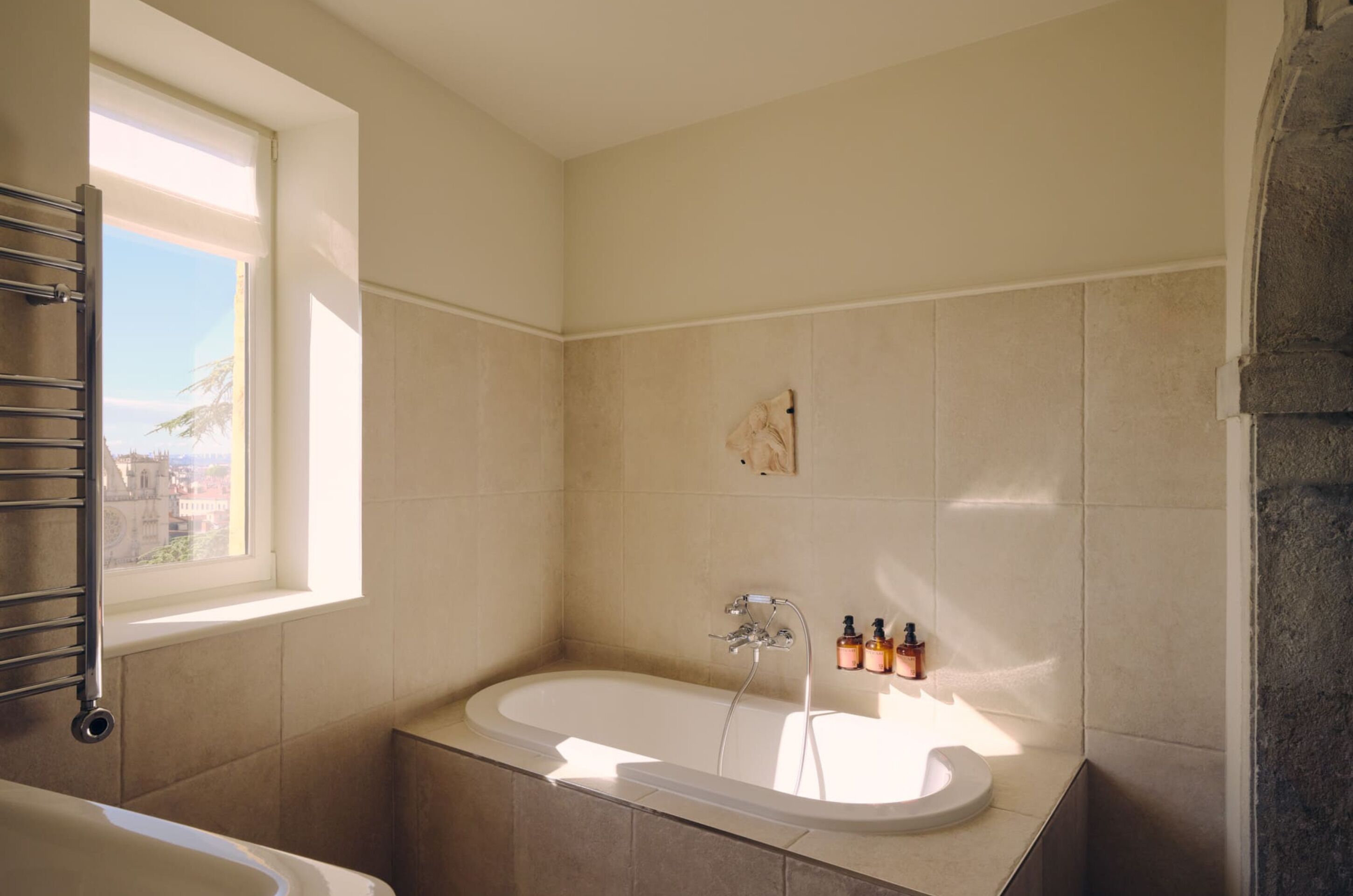 Un baño con bañera, ventana y ducha.