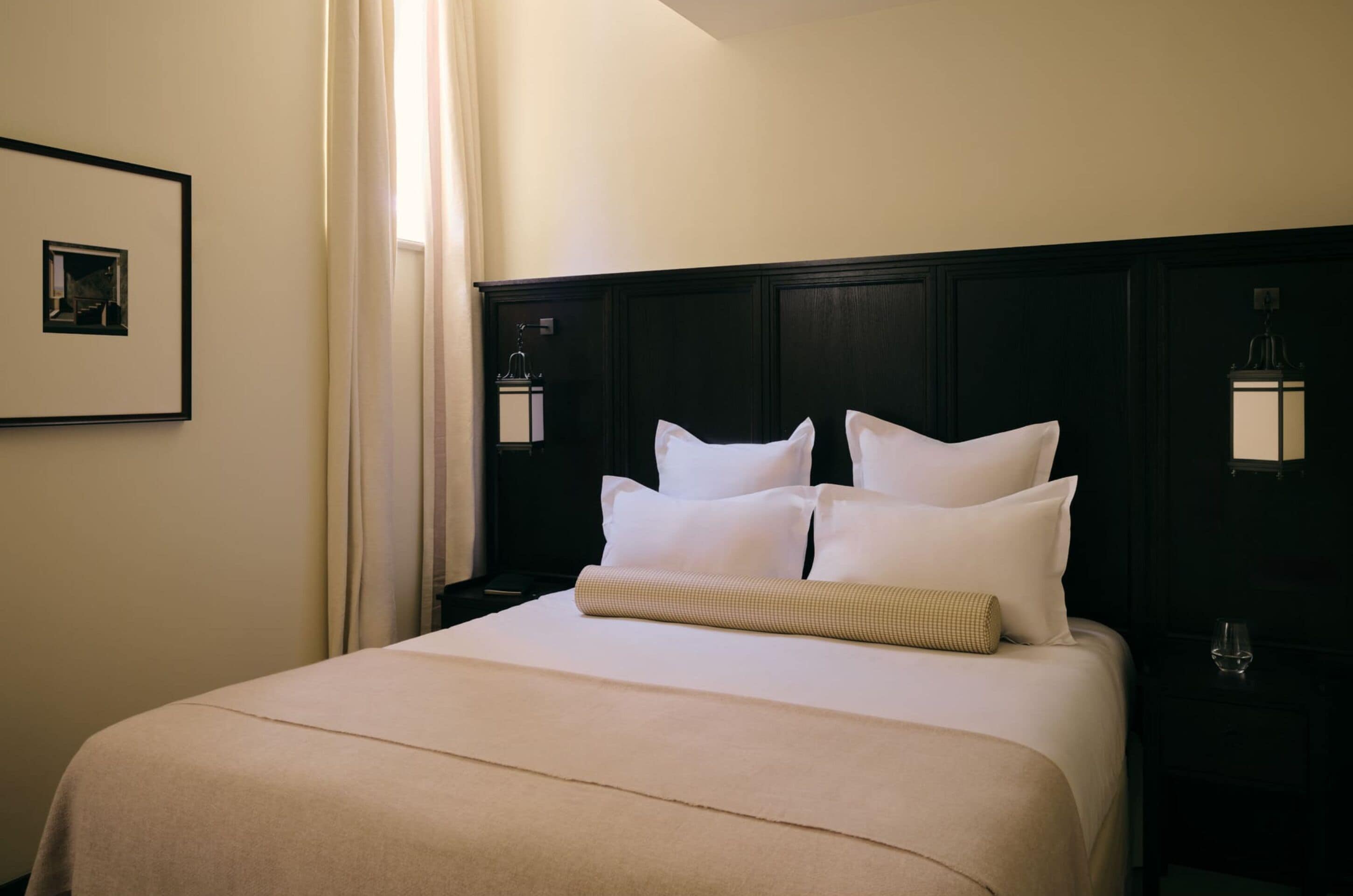 Habitación de hotel con una cama grande, una mesita de noche, una lámpara y un cuadro en la pared.