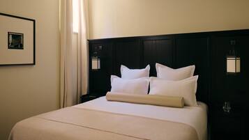 Habitación de hotel con una cama grande, una mesita de noche, una lámpara y un cuadro en la pared.