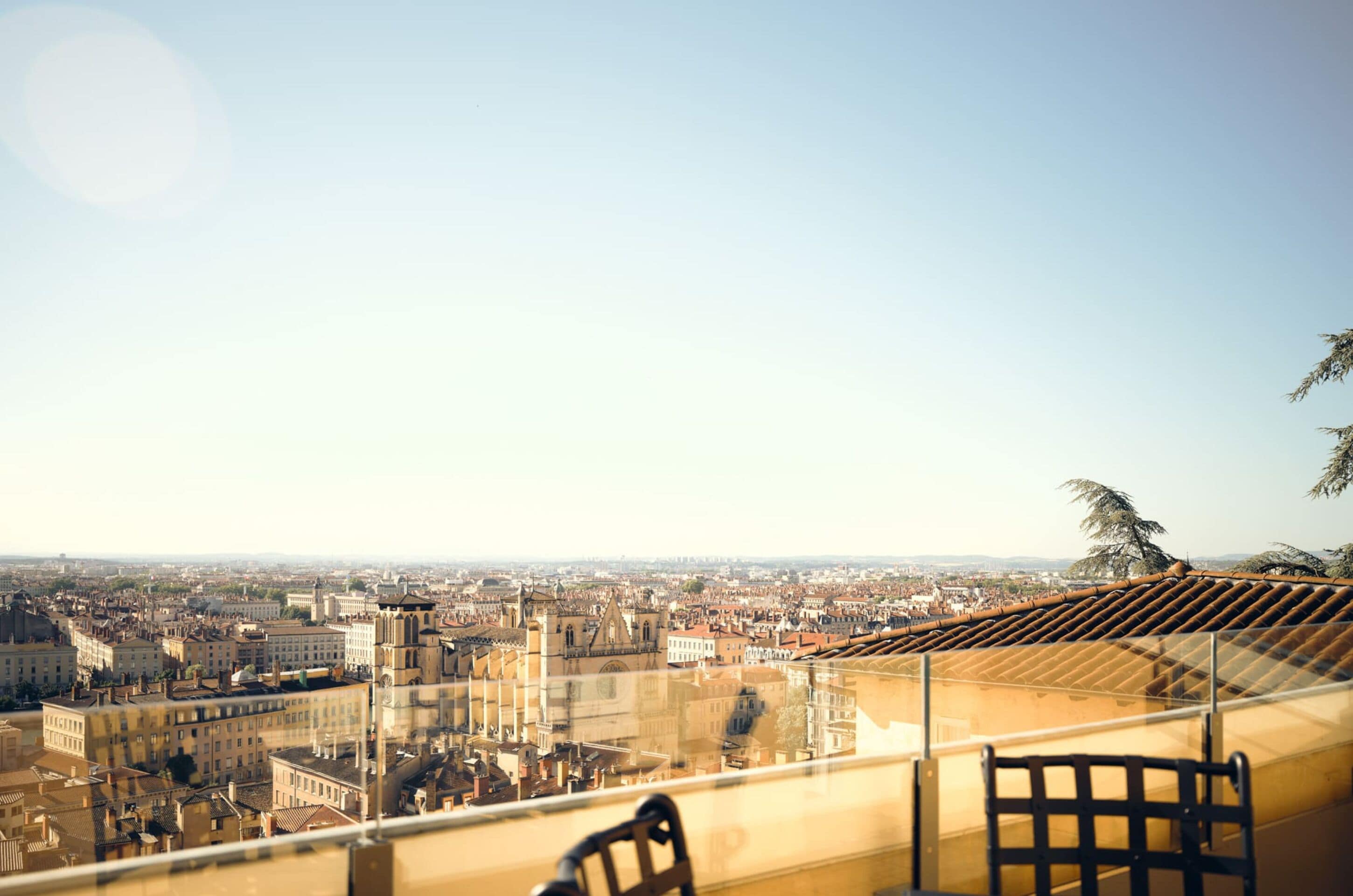 Une vue sur la ville depuis un balcon, avec un ciel dégagé.