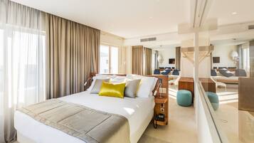 Una habitación de hotel moderna con una cama grande, un escritorio y una zona de estar.