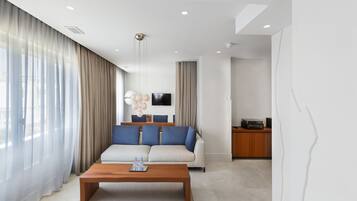 Suite, 1 cama de matrimonio grande, vistas al mar | Zona de estar | Una televisión