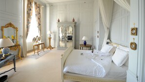 A classic bedroom with a four-poster bed, a dressing table with a mirror, and a wardrobe. - Château de Curzay (Curzay-sur-Vonne)