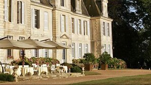 A large, historic building with a formal garden and outdoor seating area. - Château de Curzay (Curzay-sur-Vonne)